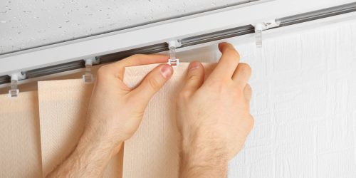 Male hands installing vertical blinds